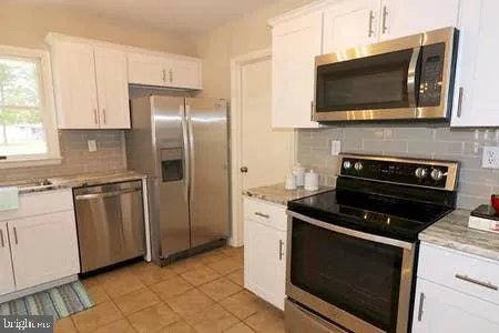 a kitchen with granite countertop a stove and a microwave