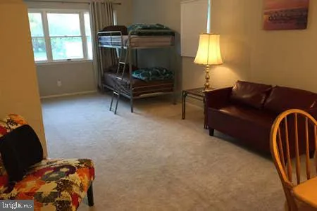 a bedroom with a bed a dresser and chair