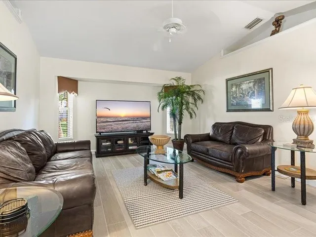 a spacious bedroom with a bed a dresser and a chandelier