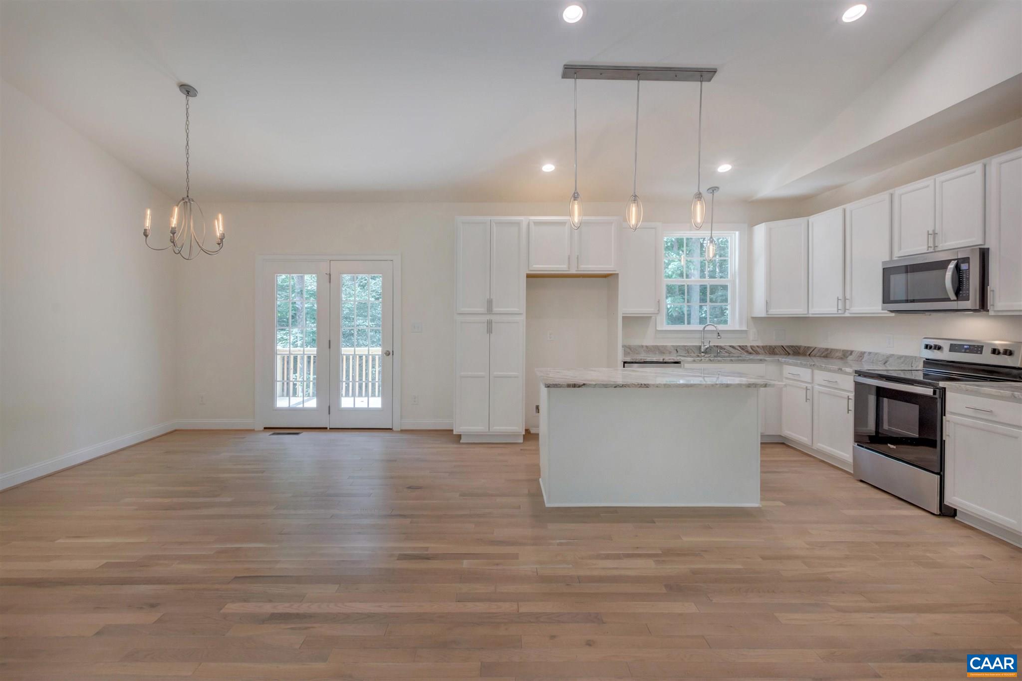312 Jonquil Road Ruckersville, VA 22968 - Photo 9 of 34 a large kitchen with granite countertop a stove top oven a sink dishwasher and white cabinets with wooden floor
