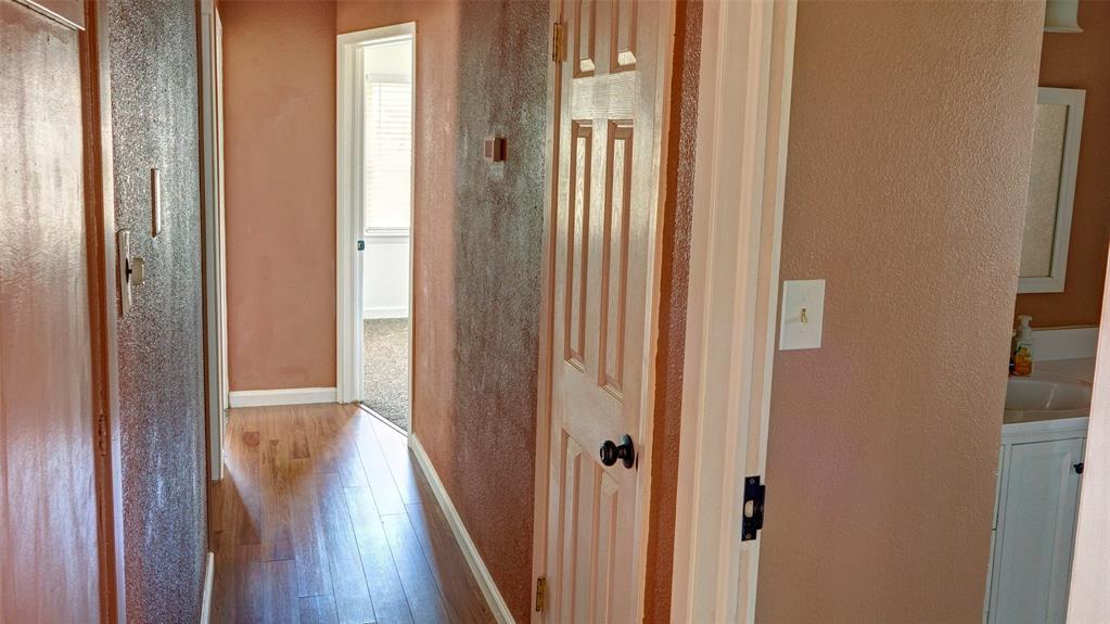 2612 West Rochelle Road Irving, TX 75062 - Photo 6 of 29 Hallway with wood finished floors, a textured wall, and washer / dryer