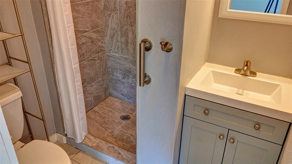 2612 West Rochelle Road Irving, TX 75062 - Photo 10 of 29 Full bath featuring vanity, a stall shower, and a textured wall