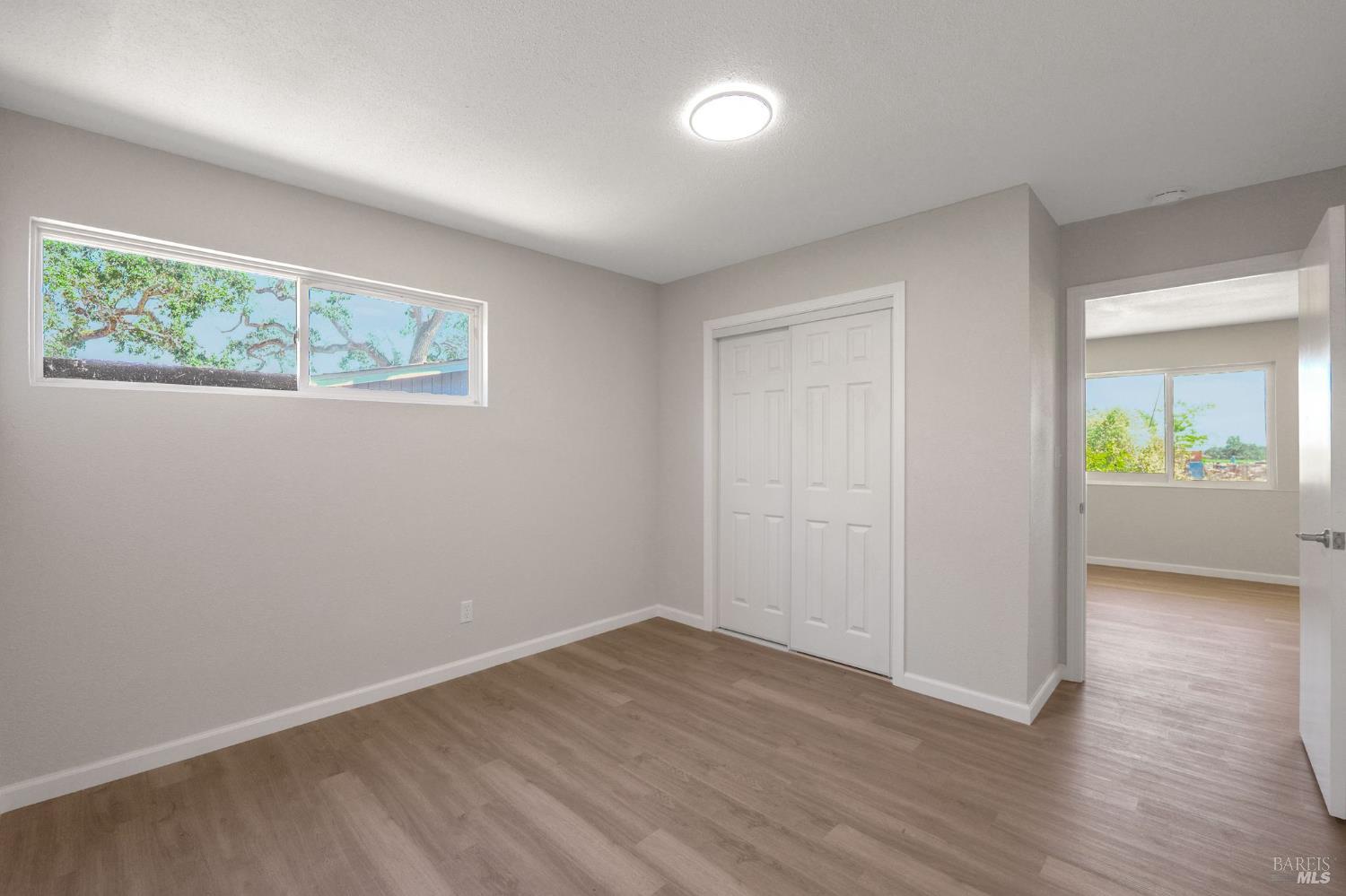 1120 Soda Canyon Road Napa, CA 94558 - Photo 13 of 38 an empty room with wooden floor and windows