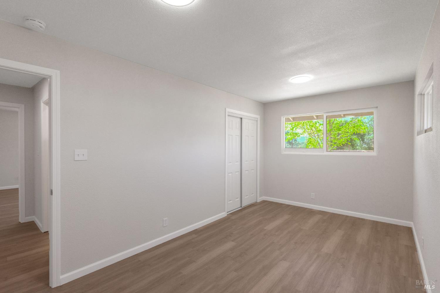 1120 Soda Canyon Road Napa, CA 94558 - Photo 24 of 38 an empty room with wooden floor and windows