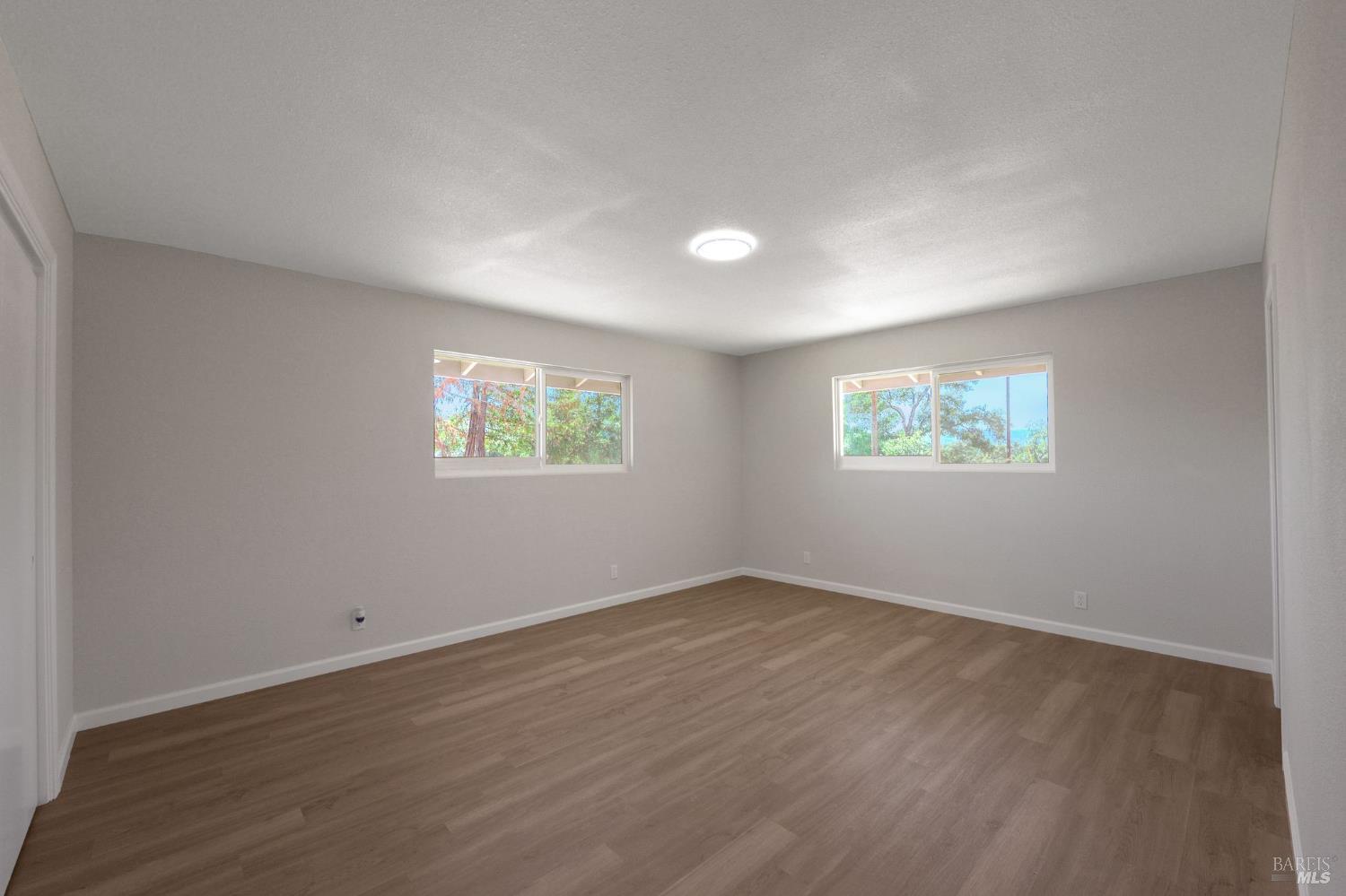 1120 Soda Canyon Road Napa, CA 94558 - Photo 25 of 38 an empty room with wooden floor and windows
