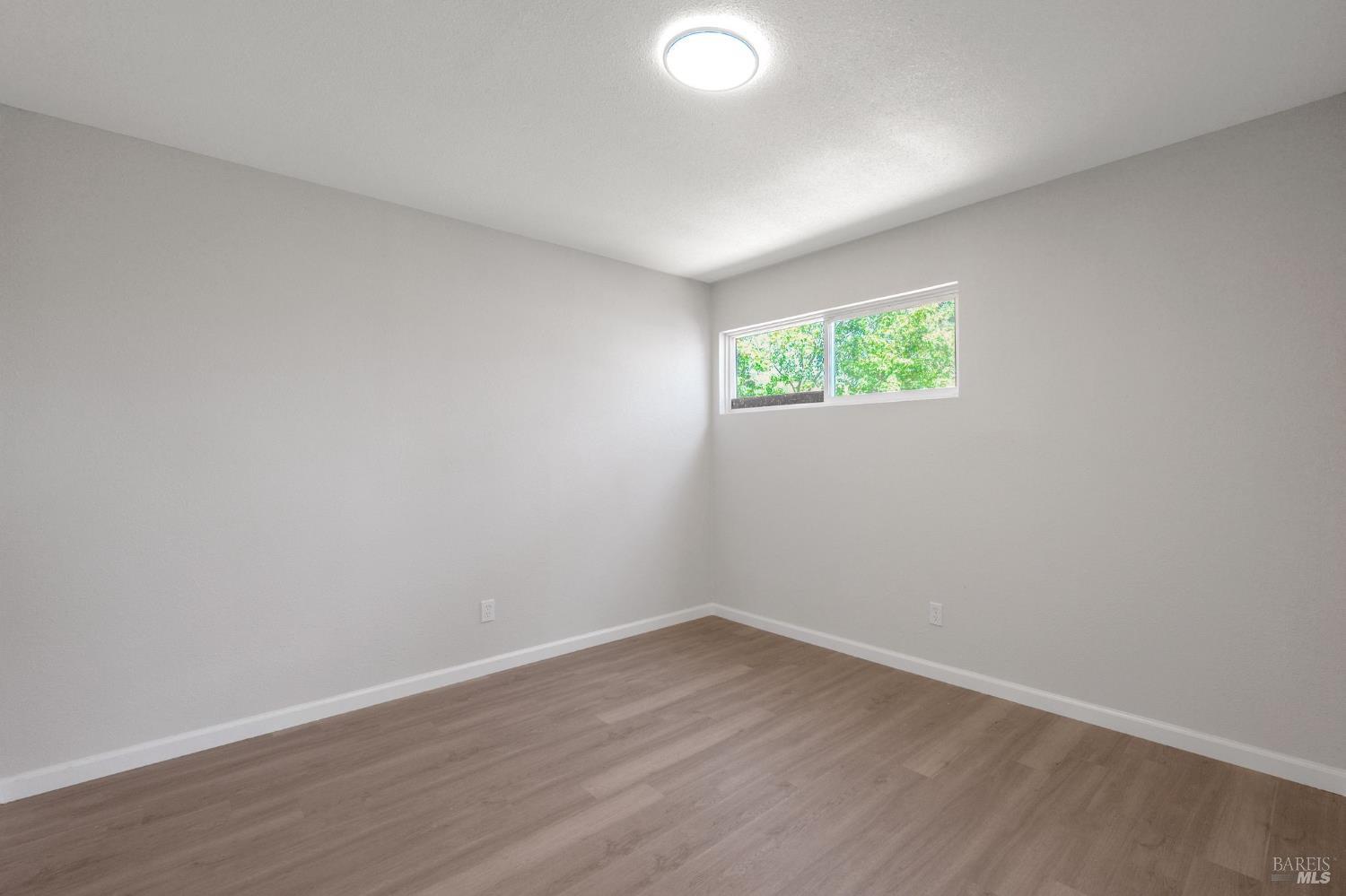 1120 Soda Canyon Road Napa, CA 94558 - Photo 31 of 38 an empty room with wooden floor and windows