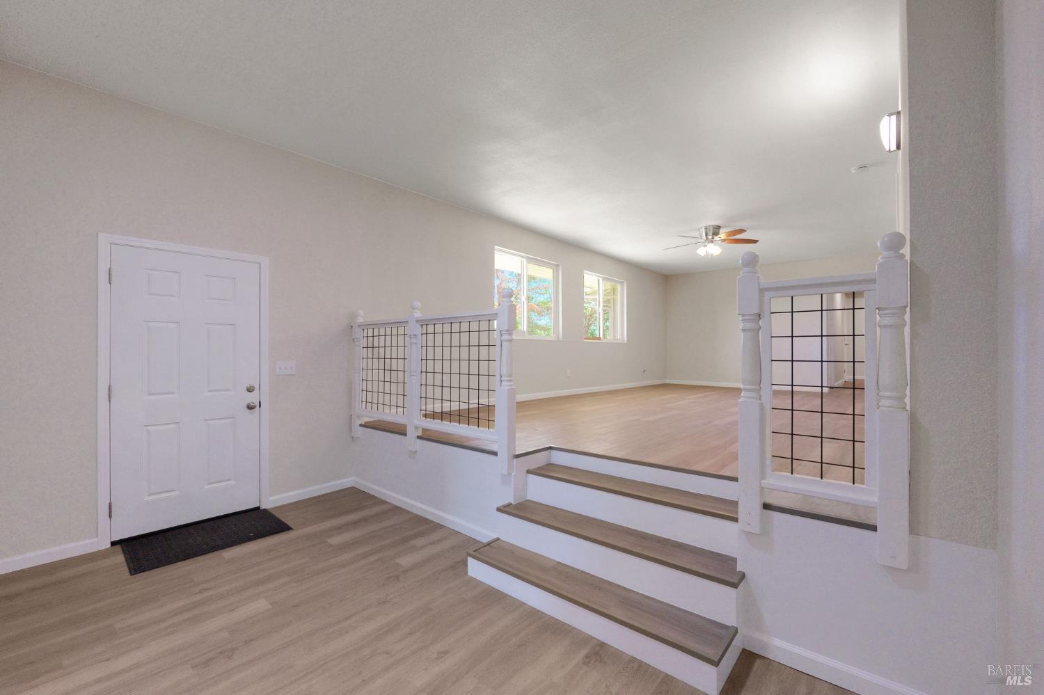 1120 Soda Canyon Road Napa, CA 94558 - Photo 6 of 38 a view of an empty room with wooden floor and windows