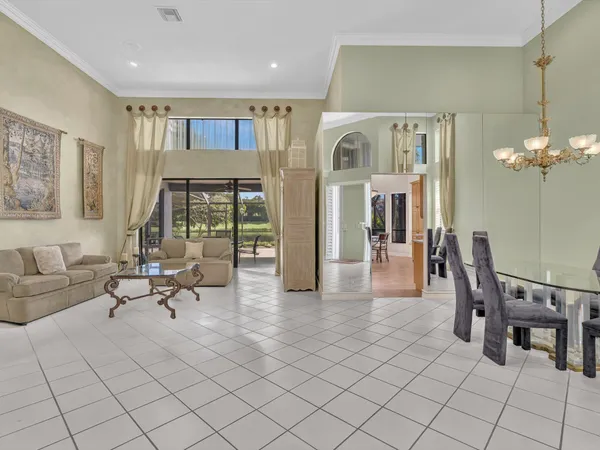 a living room with furniture a dining table and a chandelier