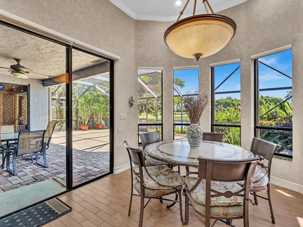 a dining room with furniture a chandelier and wooden floor