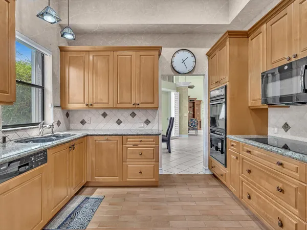 a kitchen with stainless steel appliances granite countertop a stove and cabinets