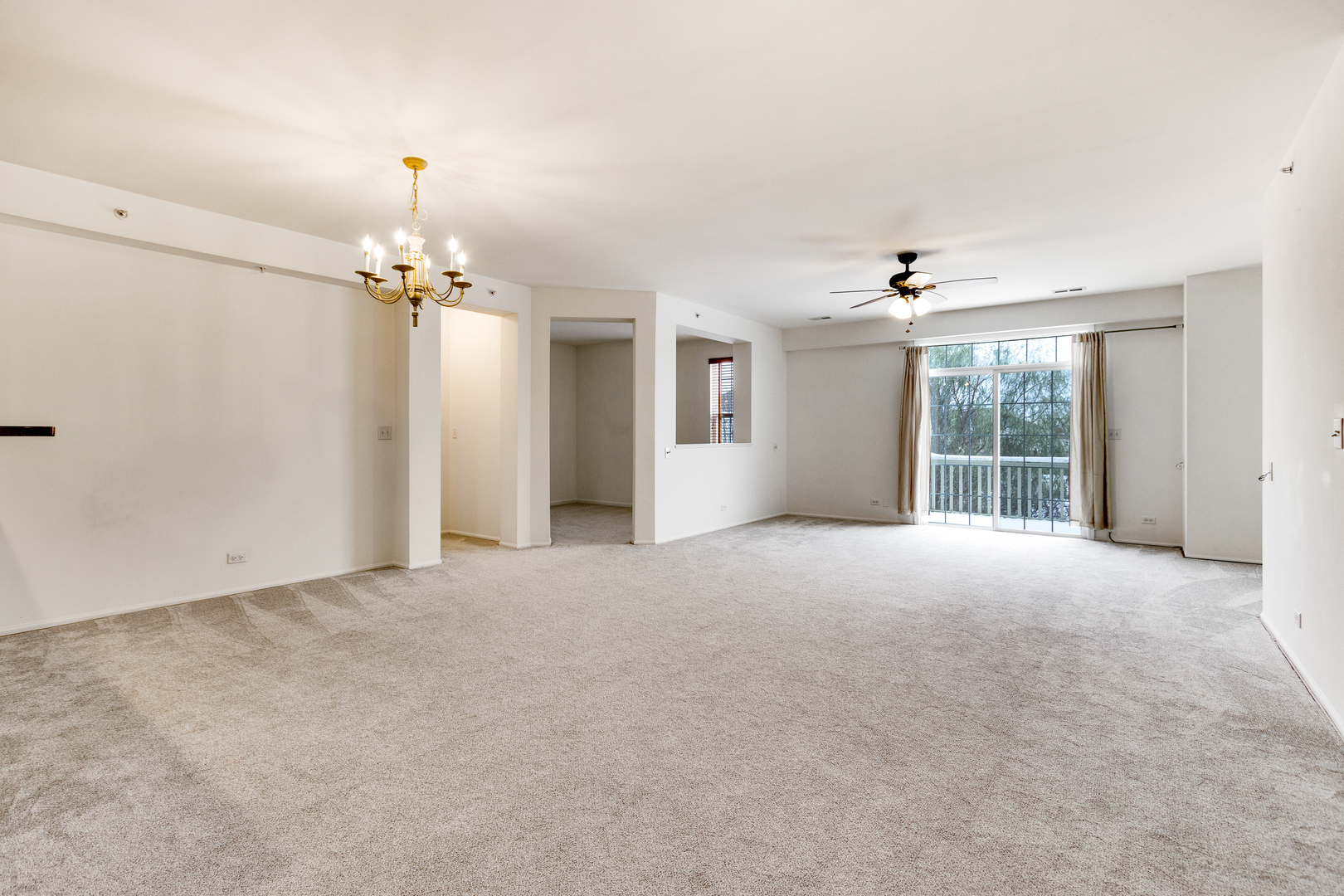 1391 Scarboro Road, Unit 201 Schaumburg, IL 60193 - Photo 4 of 20 a view of an empty room with a chandelier fan