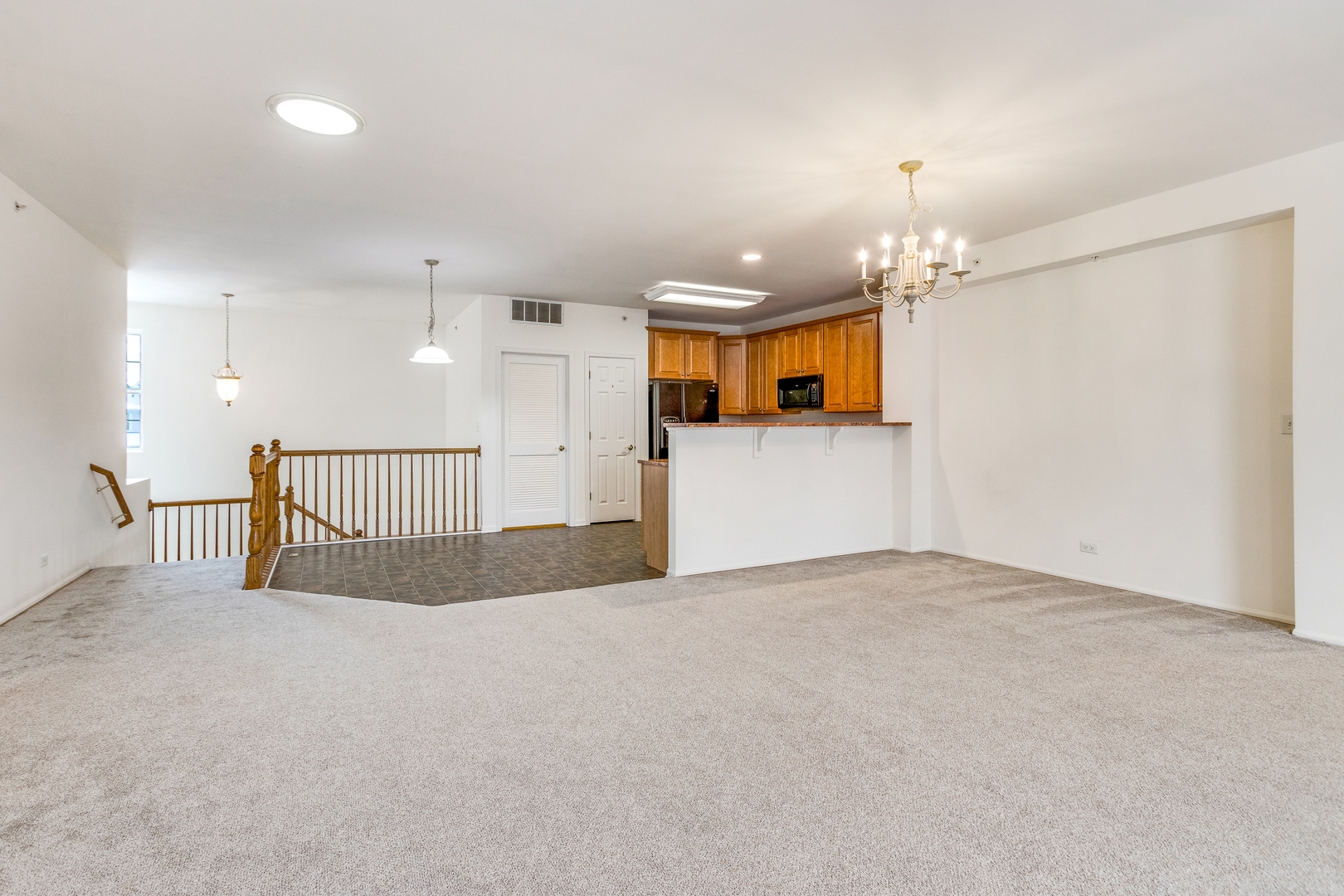 1391 Scarboro Road, Unit 201 Schaumburg, IL 60193 - Photo 6 of 20 an empty room with chandelier fan and windows
