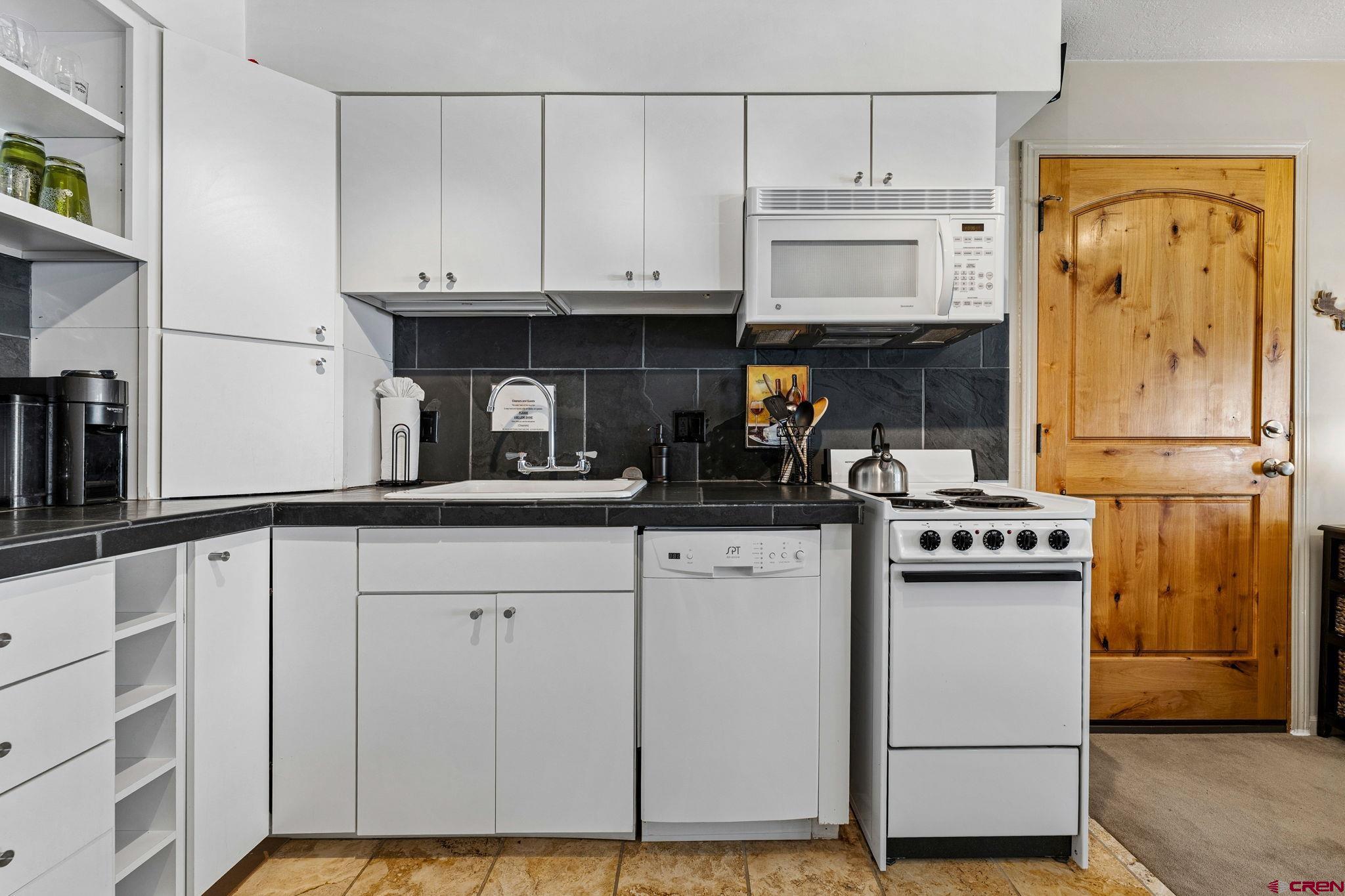 395 Sheol Street, Unit 117 Durango, CO 81301 - Photo 11 of 28 a kitchen with stainless steel appliances granite countertop a refrigerator and a stove top oven