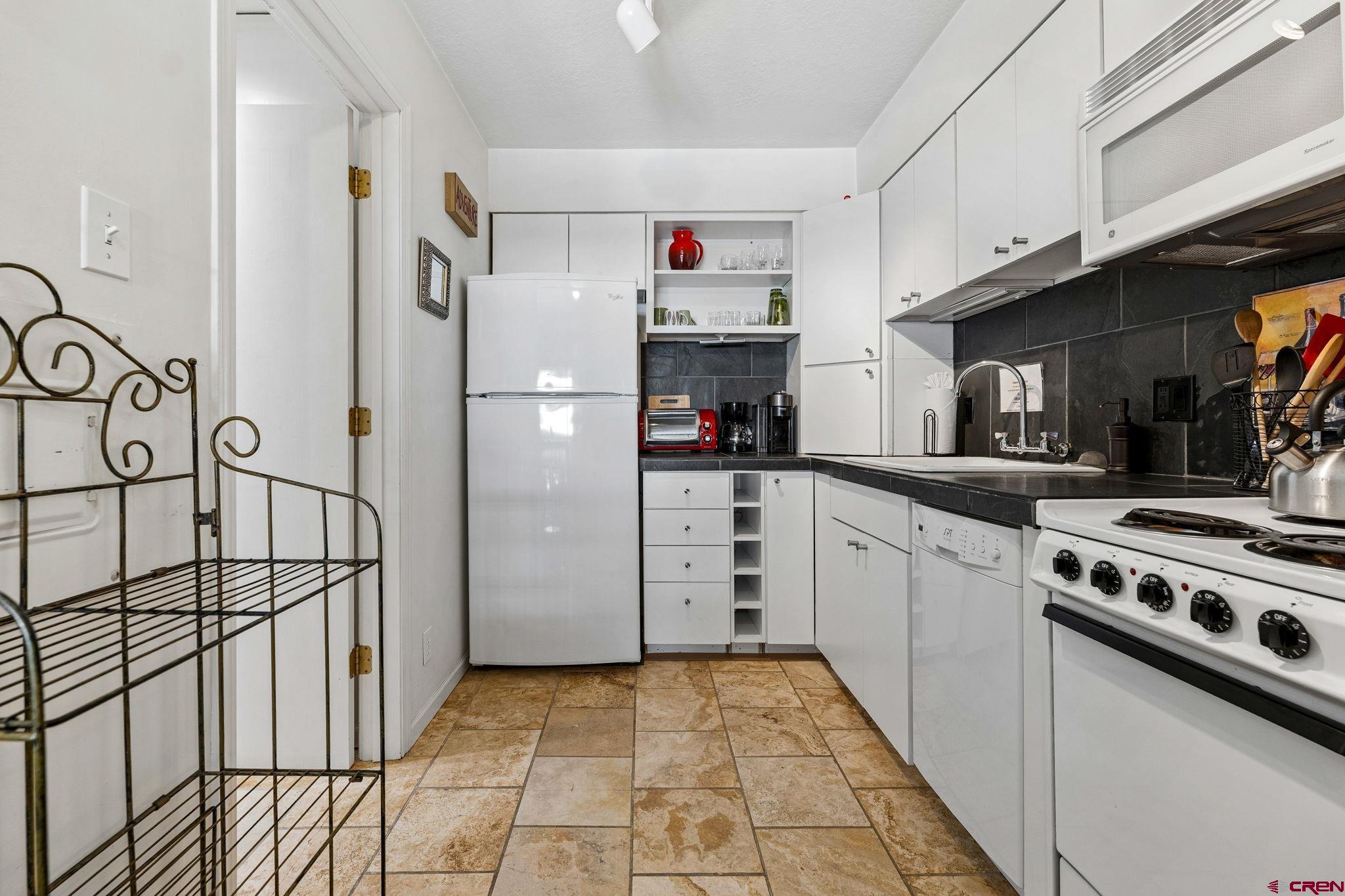 395 Sheol Street, Unit 117 Durango, CO 81301 - Photo 12 of 28 a kitchen with cabinets and white appliances