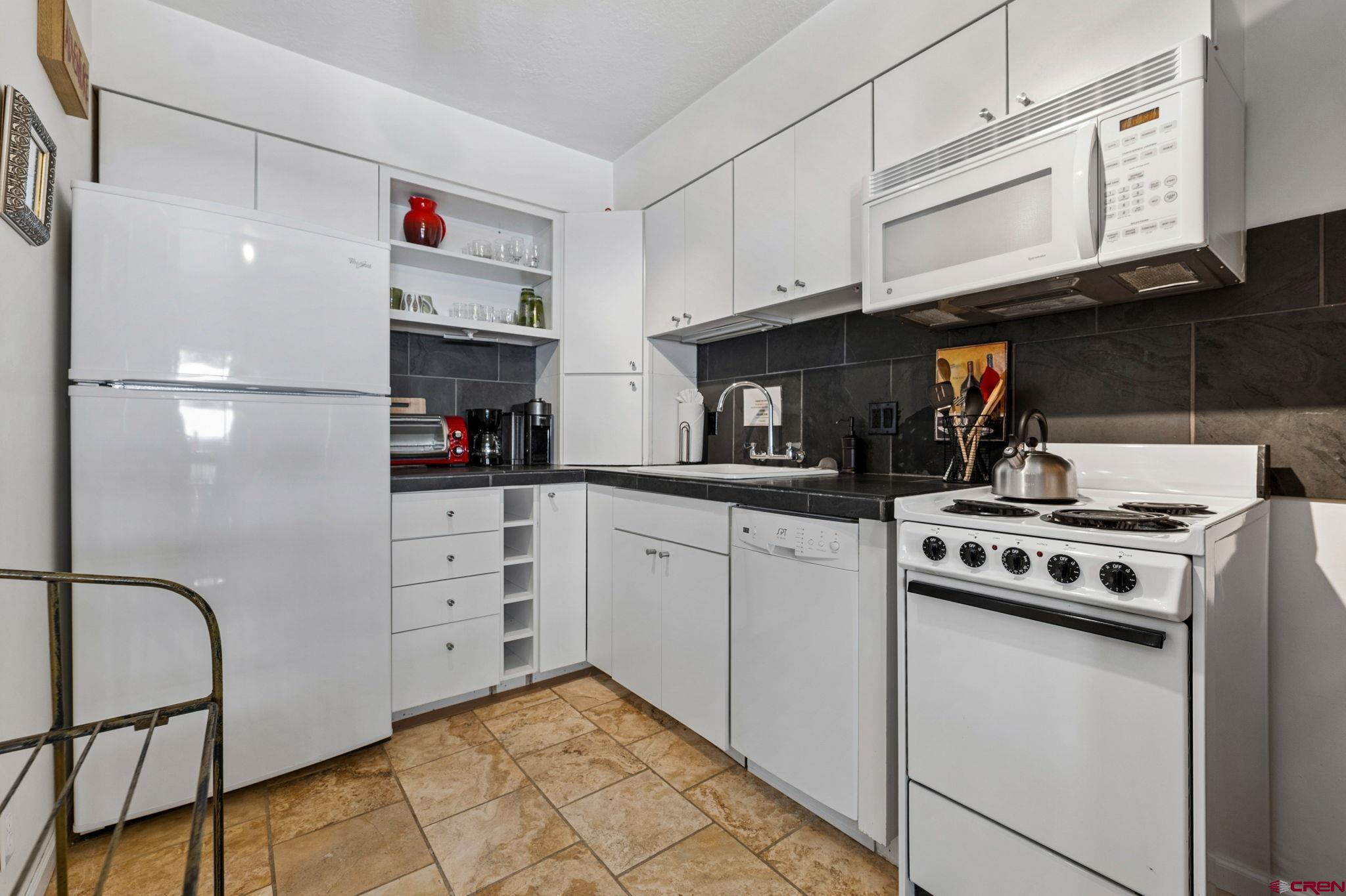 395 Sheol Street, Unit 117 Durango, CO 81301 - Photo 13 of 28 a kitchen with stainless steel appliances granite countertop a stove a refrigerator and cabinets