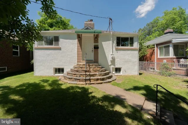 a view of a house with backyard and a tree