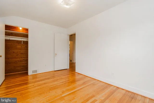 a view of an empty room with wooden floor