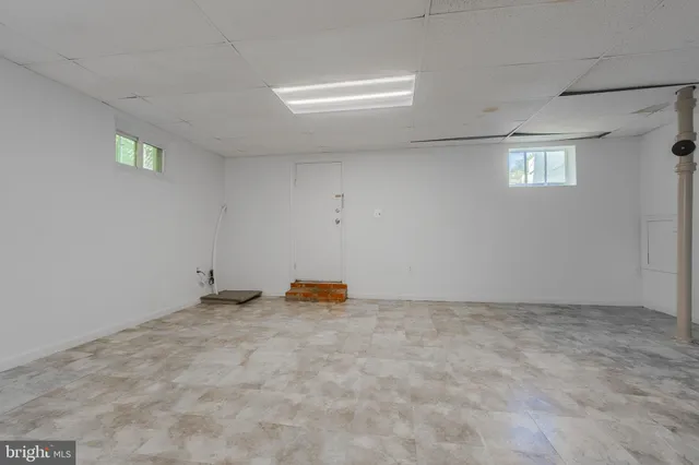 an empty room with staircase and white walls