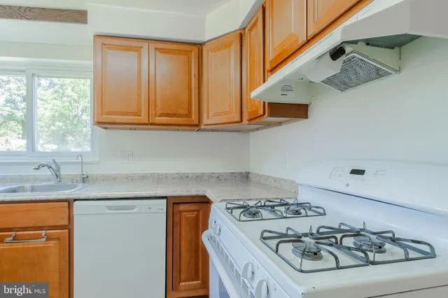 a kitchen with stainless steel appliances granite countertop a sink and a stove