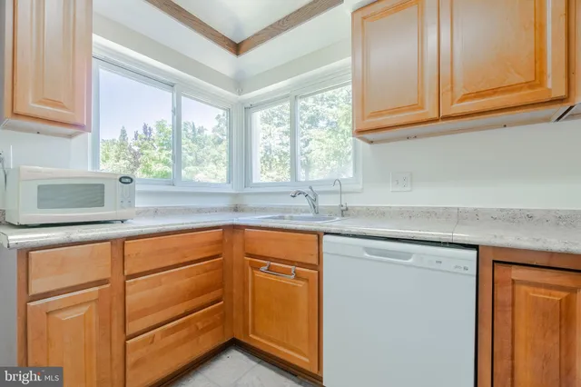 a kitchen with stainless steel appliances granite countertop a sink and a window