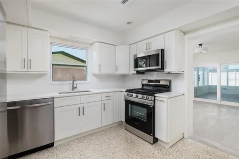 a kitchen with stainless steel appliances granite countertop a stove sink microwave and cabinets