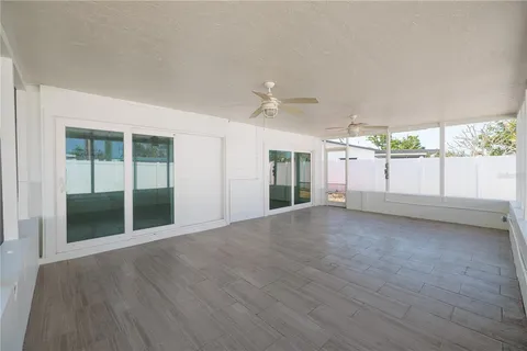 a view of a livingroom with wooden floor and a ceiling fan