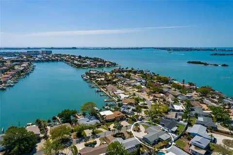 an aerial view of ocean and residential houses with outdoor space