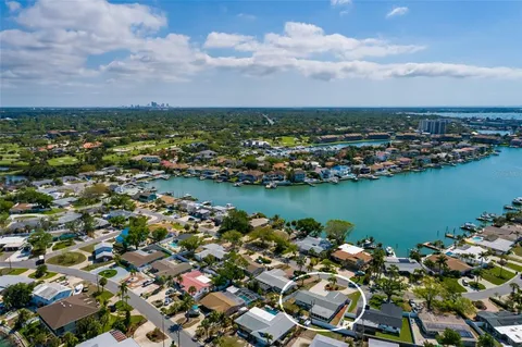 an aerial view of a city with lots of residential buildings and ocean view in back