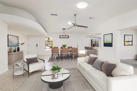 a living room with furniture and a dining table with kitchen view