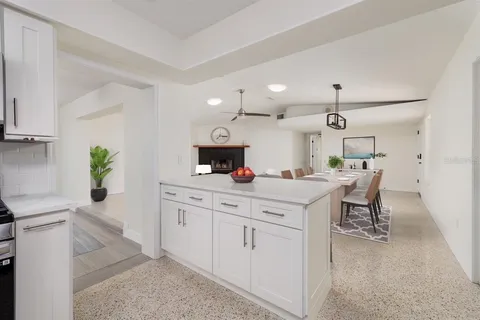 a kitchen with a white cabinets and chairs in it