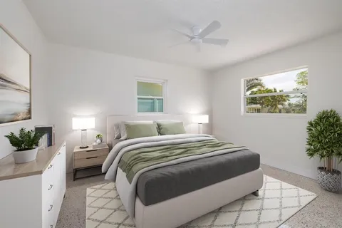 a bedroom with a bed and a potted plant