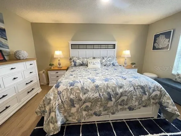 a large bed sitting in a bedroom next to a window and dresser