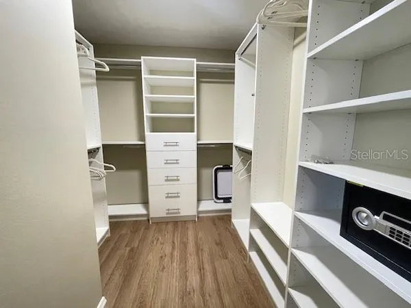 a view of walk in closet with clothes and shoes