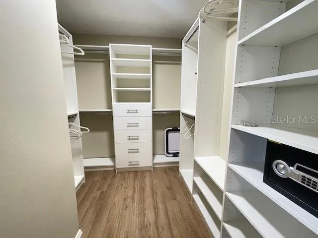 a view of walk in closet with clothes and shoes