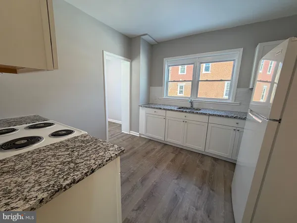 a kitchen with granite countertop a sink stove and cabinets
