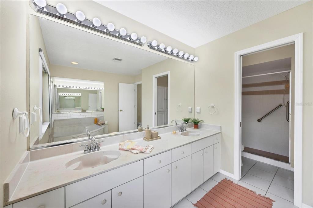 63 Clubhouse Road Rotonda West, FL 33947 - Photo 15 of 44 a en suite bathroom with a double vanity sink and mirror