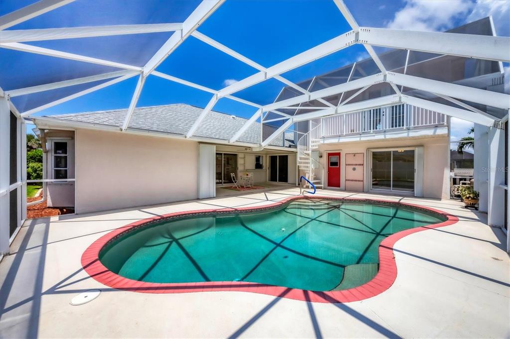 63 Clubhouse Road Rotonda West, FL 33947 - Photo 30 of 44 a view of a backyard with table and chairs under an umbrella