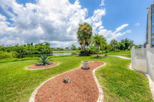 a front view of a house with a yard and palm trees