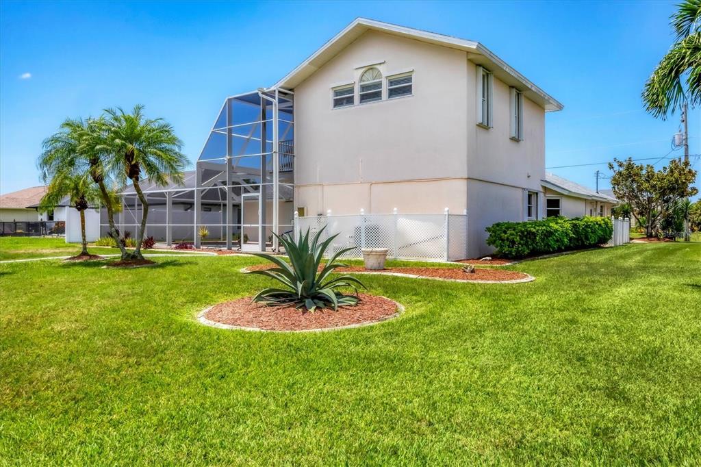 63 Clubhouse Road Rotonda West, FL 33947 - Photo 33 of 44 a front view of a house with a yard and palm trees