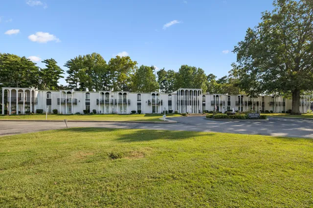 a view of swimming pool with outdoor seating and house in the background