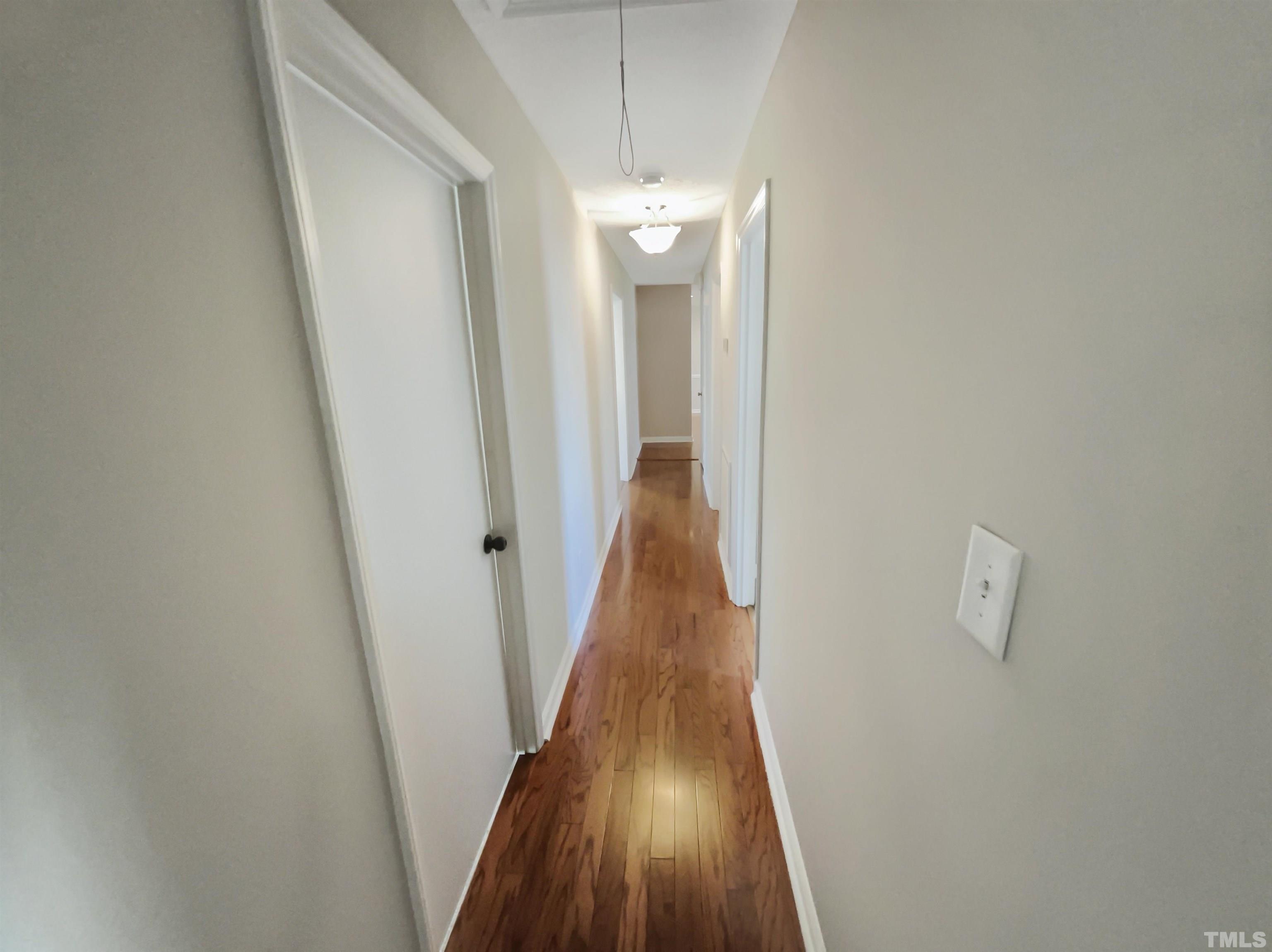 8889 Mt Pleasant Church Road Willow Spring, NC 27592 - Photo 13 of 18 a view of a hallway with wooden floor and staircase