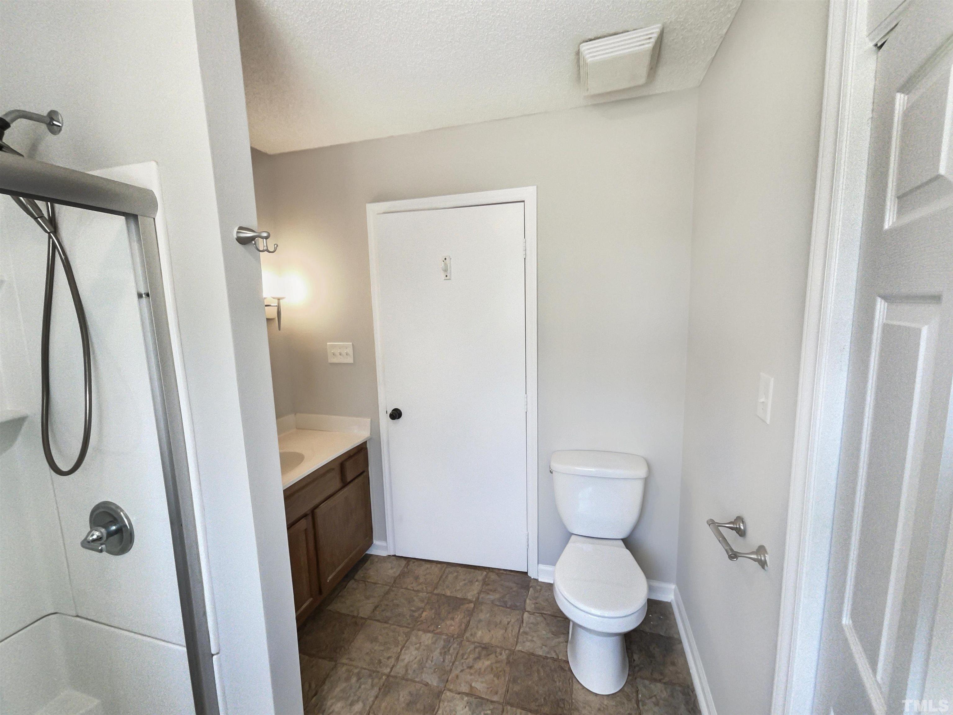 8889 Mt Pleasant Church Road Willow Spring, NC 27592 - Photo 4 of 18 a bathroom with a granite countertop toilet a sink and a shower