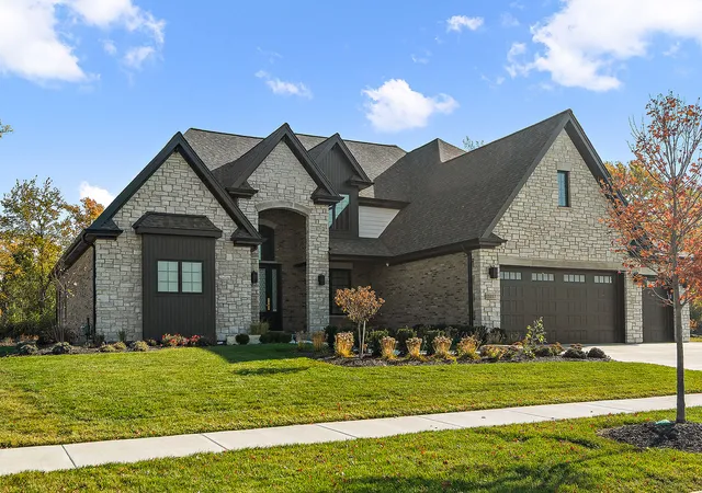 a front view of a house with a garden and yard