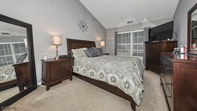 a bedroom with a bed flat screen tv and a large window