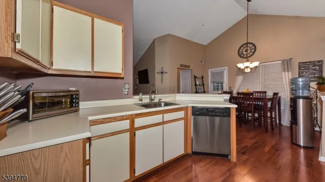 a kitchen with stainless steel appliances granite countertop a sink a stove and a wooden floors