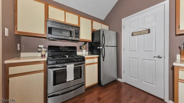 a kitchen with stainless steel appliances a stove a microwave and a hard wood floor