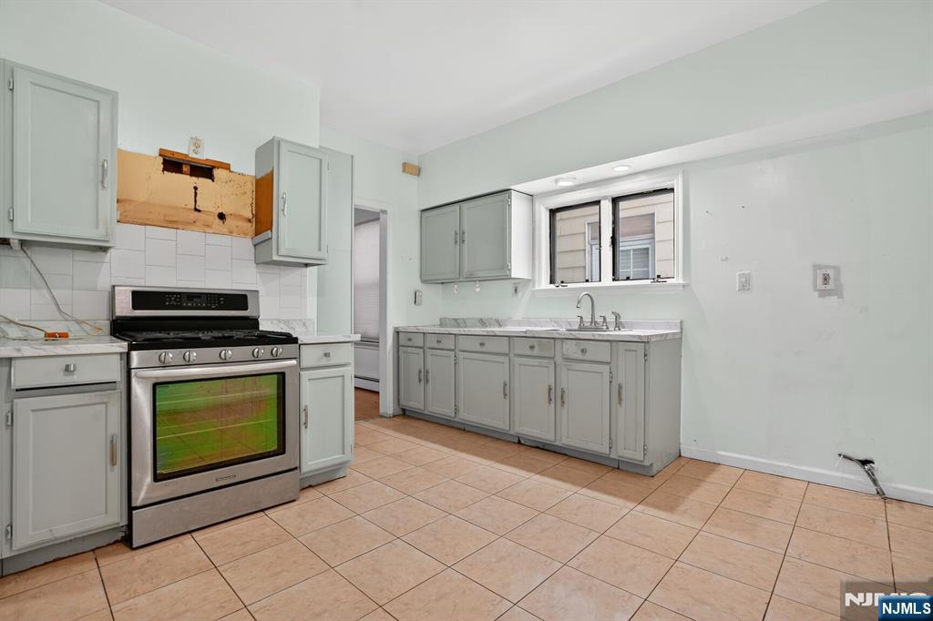 1110 Hampton Place Elizabeth, NJ 07201 - Photo 3 of 23 a kitchen with a stove sink and cabinets