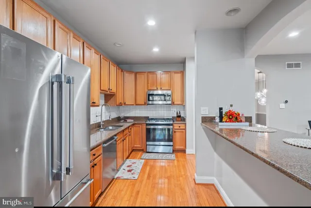 a kitchen with stainless steel appliances a refrigerator and a stove