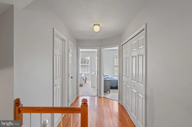a view of a hallway with wooden floor and staircase