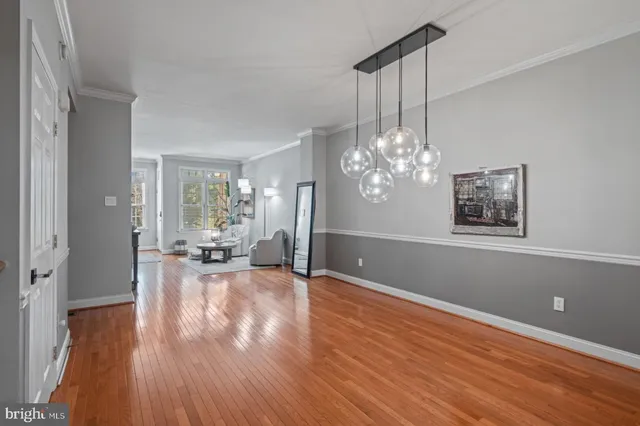 a view of a livingroom with wooden floor and a chandelier